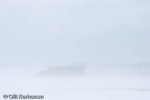 A barn in a fog.