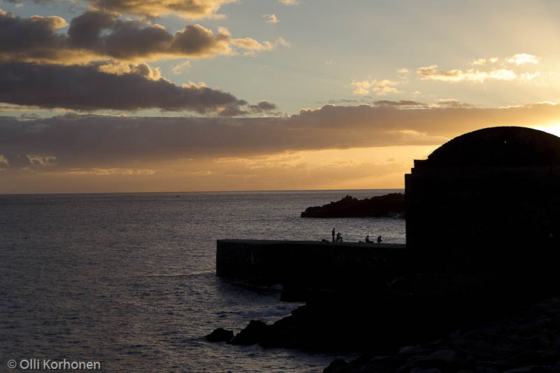 Kalastajia aallonmurtajalla auringonlaskun aikaan, Funchal, Madeira.