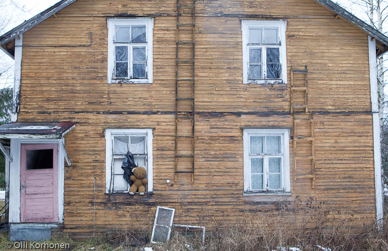 Hylätty Nalle ja autio kaksikerroksinen puutalo.