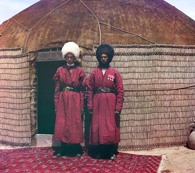 Kaksi miestä seisoo matolla jurtan edessä.